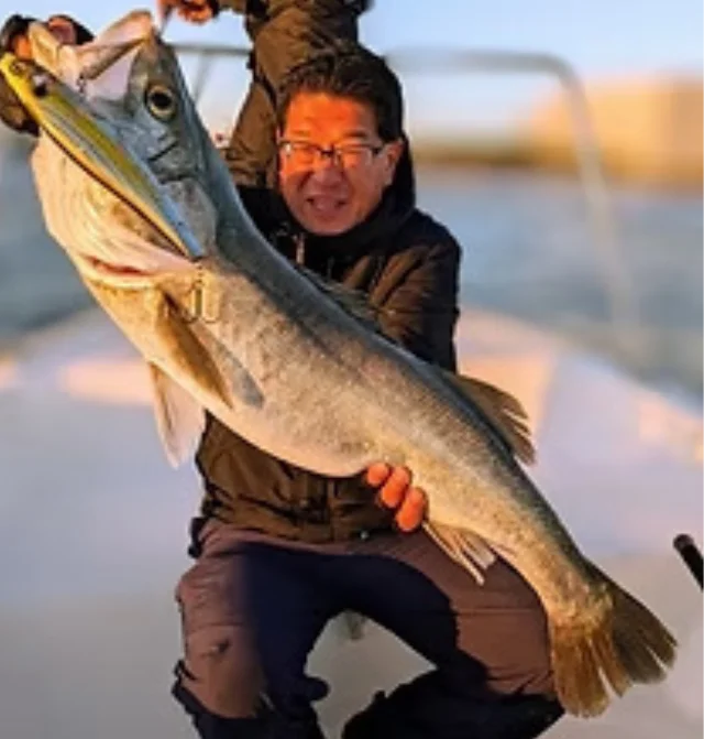 船上で釣り上げた大きな魚を抱える川口博史